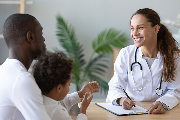 medical professional interviewing a father and child